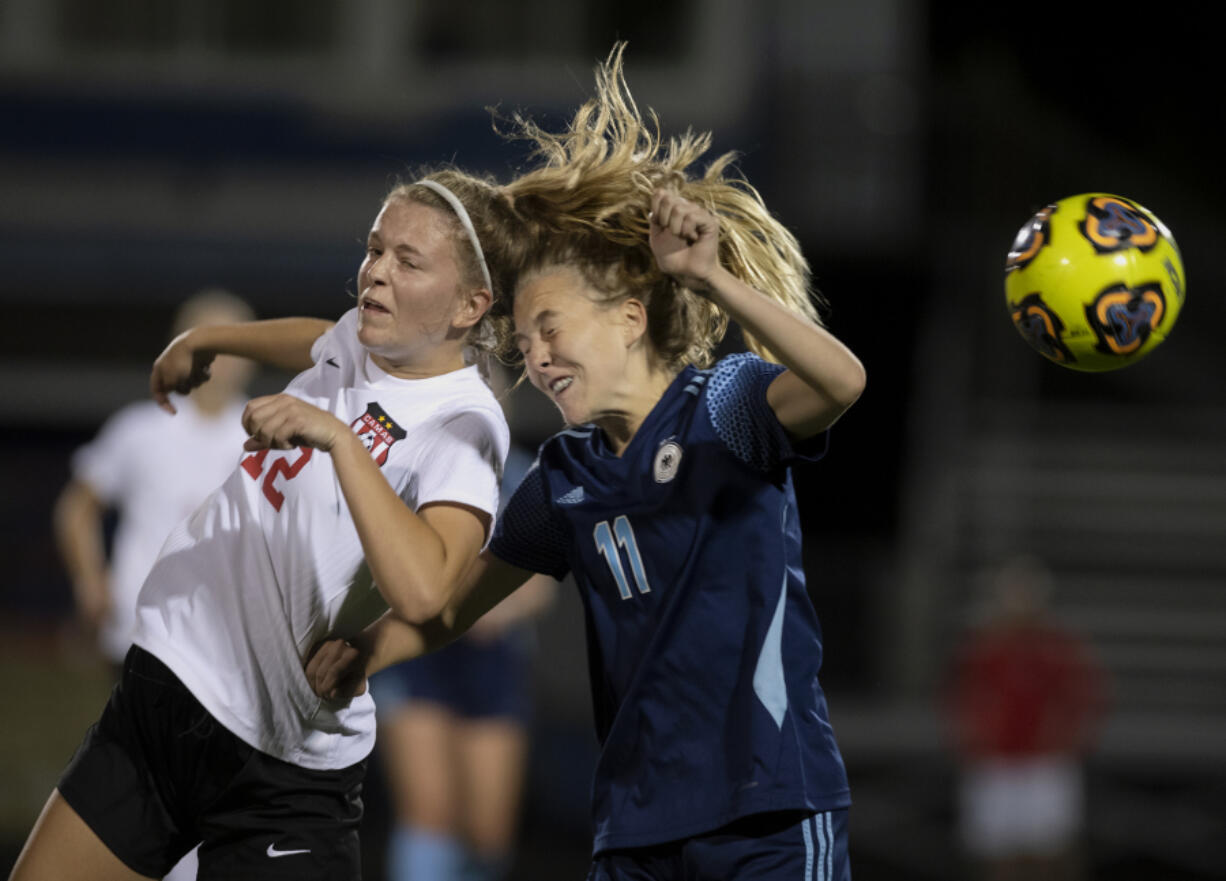 Camas junior Anna Mooney, left, wins a header over Hockinson sophomore Ani Vossler during the season-opening match Tuesday. Camas won 3-1.