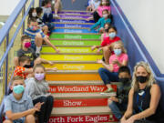 Leadership/SEL teacher Stacia Aschoff, far right, sits with her leadership class on the stairs of North Fork Elementary School in Woodland.