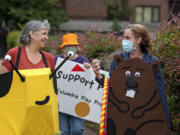 Columbia Play Project performers Jeanne Bennett, from left, Mary Sisson and Maureen Montague make their way through downtown Vancouver during a fundraiser for Give More 24! on Thursday morning. The nonprofit is working to build a children's museum in Vancouver.