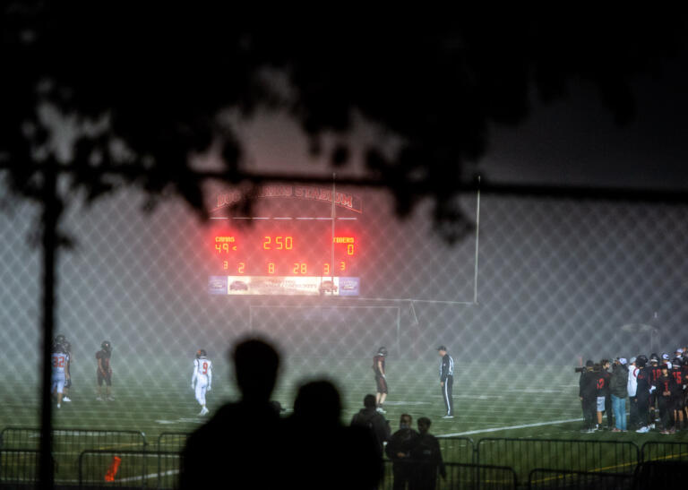 A couple snuggles up outside the stadium fencing to watch the third quarter in a 4A Greater St. Helens League football game on Thursday, Sept. 30, 2021, at Doc Harris Stadium in Camas. Camas won 56-6 over Battle Ground.