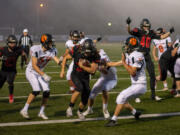 Jon Schultz, center, beats three Battle Ground defenders into the end zone for a game-opening score in a 4A Greater St. Helens League football game on Thursday, Sept. 30, 2021, at Doc Harris Stadium in Camas. Camas beat Battle Ground 56-6.