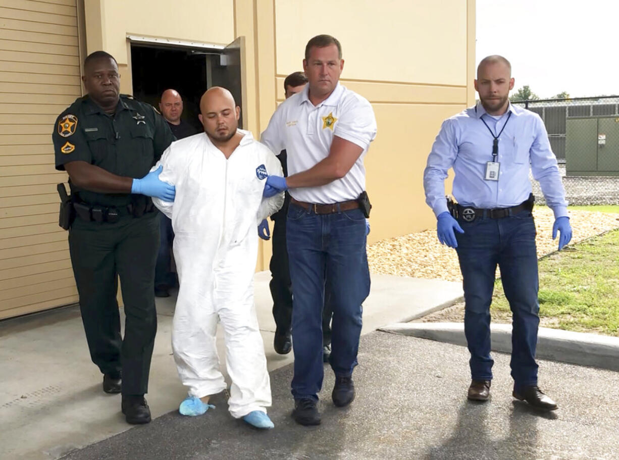 Quadruple murder suspect Bryan Riley is led from the Polk County Sheriff’s Office in Lakeland, Fla., on Sunday, Sept. 5, 2021, by Deputy Steve Neil, left, Captain Bart Davis and Detective Brett Bulman. (Kimberly C.