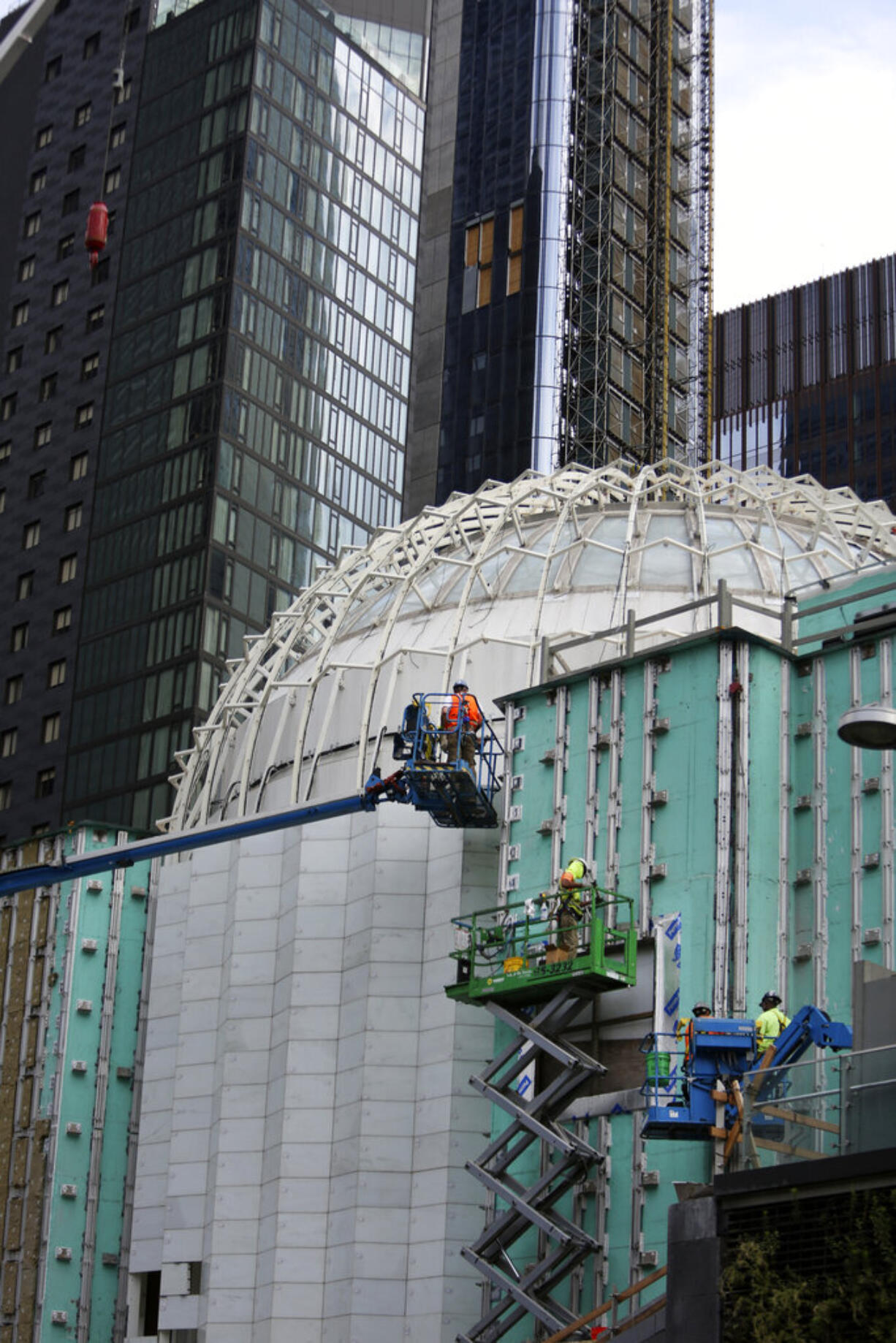 Workers install marble on the exterior of St. Nicholas Greek Orthodox Church and National Shrine, the only house of worship on ground zero, on Thursday, July 22, 2021, in New York. Through an innovative process, interior lights are being designed to illuminate thin panels of marble mined from the same Pentelic vein in Greece that sourced the Parthenon, the ancient temple in Athens. The shrine will have a ceremonial lighting on the eve of the 20th anniversary of the Sept. 11, 2001 attacks, while the interior is slated for completion next year.