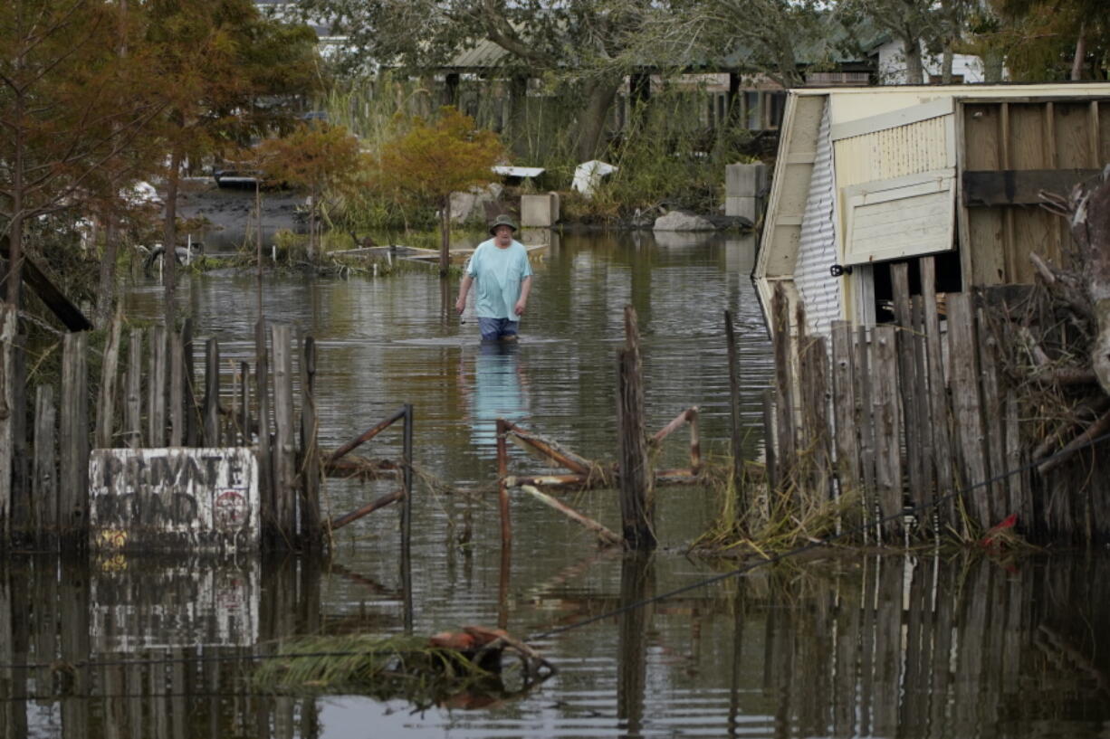 A man walks down a flooded street in the aftermath of Hurricane Ida, Wednesday, Sept. 1, 2021, in Lafitte, La.