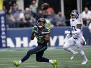 Seattle Seahawks wide receiver Tyler Lockett (16) catches a pass before running for a touchdown in from of Tennessee Titans strong safety Bradley McDougald, right, during the first half of an NFL football game, Sunday, Sept. 19, 2021, in Seattle.