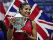 Emma Raducanu, of Britain, holds up the US Open championship trophy after defeating Leylah Fernandez, of Canada, during the women's singles final of the US Open tennis championships, Saturday, Sept. 11, 2021, in New York.