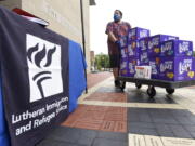 FILE - In this Tuesday, Aug. 31, 2021, file photo, Berny Lopez, an operations specialist for Lutheran Immigration and Refugee Service, moves donated diapers at the organization's drop-off site for items to help refugees from Afghanistan, in Baltimore. Many different religion groups across the U.S. are gearing up to assist the thousands of incoming refugees.