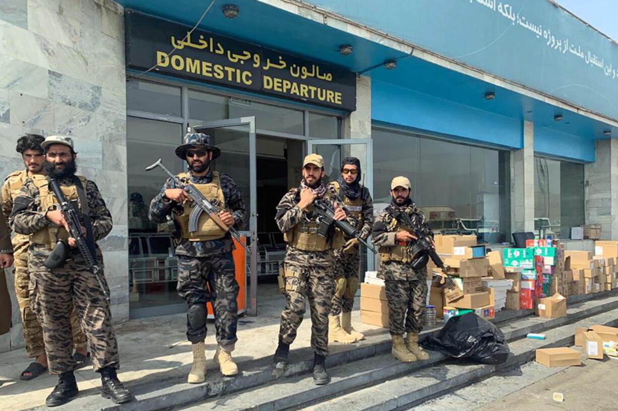 FILE - In this Aug. 31, 2021 file photo, Taliban fighters stand guard inside the Hamid Karzai International Airport after the U.S. withdrawal in Kabul, Afghanistan. Taliban authorities will allow between 100 and 150 Americans to fly out from Kabul in the coming hours, Qatari officials said on Thursday, Sept. 9, 2021, marking the airport's first such flight since U.S. forces withdrew from the country. The large group of foreigners, including Americans and other Westerners, would depart Thursday on a Qatar Airways flight that had earlier ferried humanitarian aid to the country, officials said.