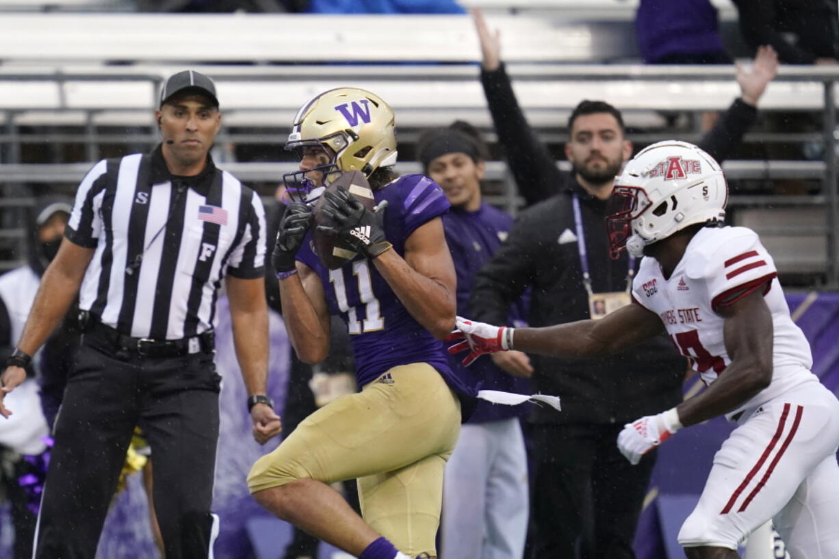 Washington's Jalen McMillan (11) scores on a 33-yard pass reception as Arkansas State's Denzel Blackwell defends in the first half of an NCAA college football game, Saturday, Sept. 18, 2021, in Seattle.