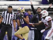 Washington's Jalen McMillan (11) scores on a 33-yard pass reception as Arkansas State's Denzel Blackwell defends in the first half of an NCAA college football game, Saturday, Sept. 18, 2021, in Seattle.