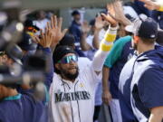 Seattle Mariners' J.P. Crawford is congratulated by teammates after scoring against the Houston Astros during the sixth inning of a baseball game Wednesday, Sept. 1, 2021, in Seattle.