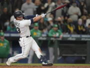 Seattle Mariners' Ty France hits a sacrifice fly to score Dylan Moore during the seventh inning of a baseball game against the Oakland Athletics, Wednesday, Sept. 29, 2021, in Seattle. (AP Photo/Ted S.