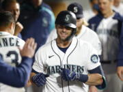 Seattle Mariners' Mitch Haniger celebrates in the dugout after hitting a solo home run in the seventh inning of a baseball game against the Oakland Athletics Tuesday, Sept. 28, 2021, in Seattle.