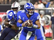 BYU quarterback Jaren Hall looks to hand off the ball against Arizona during the second half of an NCAA college football game Saturday, Sept. 4, 2021, in Las Vegas.