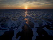 FILE - In this July 22, 2017, file photo the midnight sun shines across sea ice along the Northwest Passage in the Canadian Arctic Archipelago. The Biden administration is stepping up its work to figure about what to do about the thawing Arctic, which is warming three times faster than the rest of the world. The White House said Friday, Sept. 24, 2021, that it is reactivating the Arctic Executive Steering Committee, which coordinates domestic regulations and works with other Arctic nations. It also is adding six new members to the U.S. Arctic Research Commission, including two indigenous Alaskans.