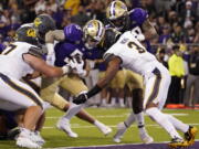 Washington's Sean McGrew (5) scores against California in the second quarter to put the Huskies on top 21-7. Much later, McGrew scored the go-ahead touchdown in overtime as UW won its Pac-12 Conference opener Saturday.