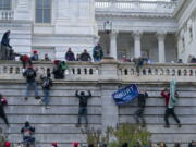 FILE - In this Jan. 6, 2021 file photo, rioters climb the west wall of the the U.S. Capitol in Washington. A House committee investigating the U.S. Capitol insurrection has requested that telecommunications and social media companies preserve the personal communications of hundreds of people who may have somehow been connected to the attack.