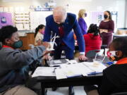 FILE - In this Sept. 10, 2021, file photo President Joe Biden talks to students at Brookland Middle School in Washington, as first lady Jill Biden talks with Brookland Middle School science teacher Michelle Taylor, right rear. As Democrats push ahead with Biden's $3.5 trillion rebuilding plan, they are promising historic investments across all levels of education. The proposal includes universal prekindergarten, two years of free community college and expanded child care subsidies, among others.