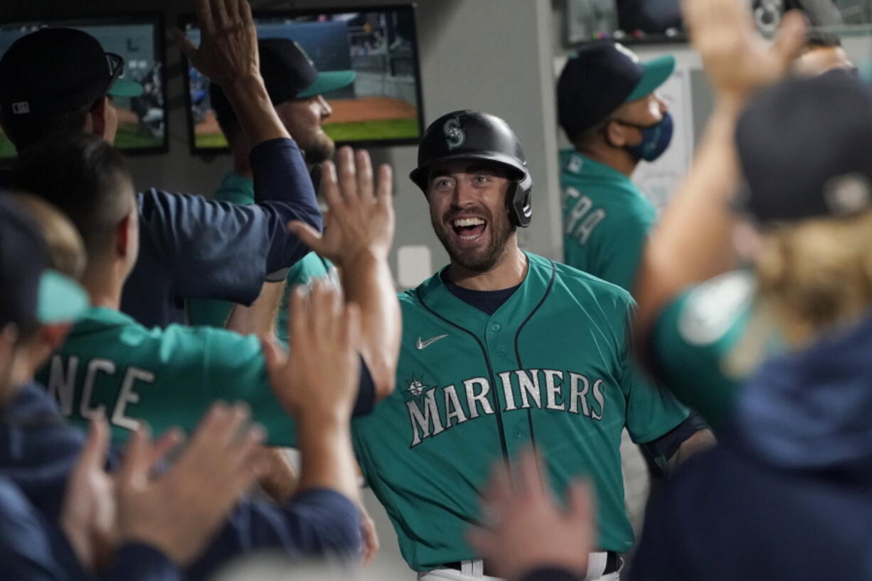 Seattle Mariners' Tom Murphy reacts in the dugout after hitting a two-run home run to also score Luis Torrens during the second inning of a baseball game against the Arizona Diamondbacks, Friday, Sept. 10, 2021, in Seattle. (AP Photo/Ted S.