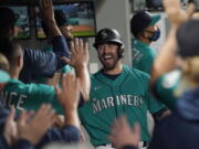 Seattle Mariners' Tom Murphy reacts in the dugout after hitting a two-run home run to also score Luis Torrens during the second inning of a baseball game against the Arizona Diamondbacks, Friday, Sept. 10, 2021, in Seattle. (AP Photo/Ted S.