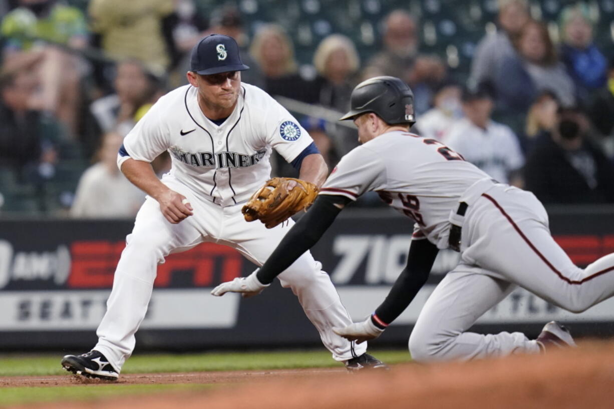 Arizona Diamondbacks' Pavin Smith, right, slides toward a tag by Seattle Mariners third baseman Kyle Seager during the fourth inning of a baseball game Saturday, Sept. 11, 2021, in Seattle. Smith was out on the double play, along with Nick Ahmed, who flied out.