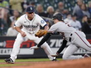 Arizona Diamondbacks' Pavin Smith, right, slides toward a tag by Seattle Mariners third baseman Kyle Seager during the fourth inning of a baseball game Saturday, Sept. 11, 2021, in Seattle. Smith was out on the double play, along with Nick Ahmed, who flied out.