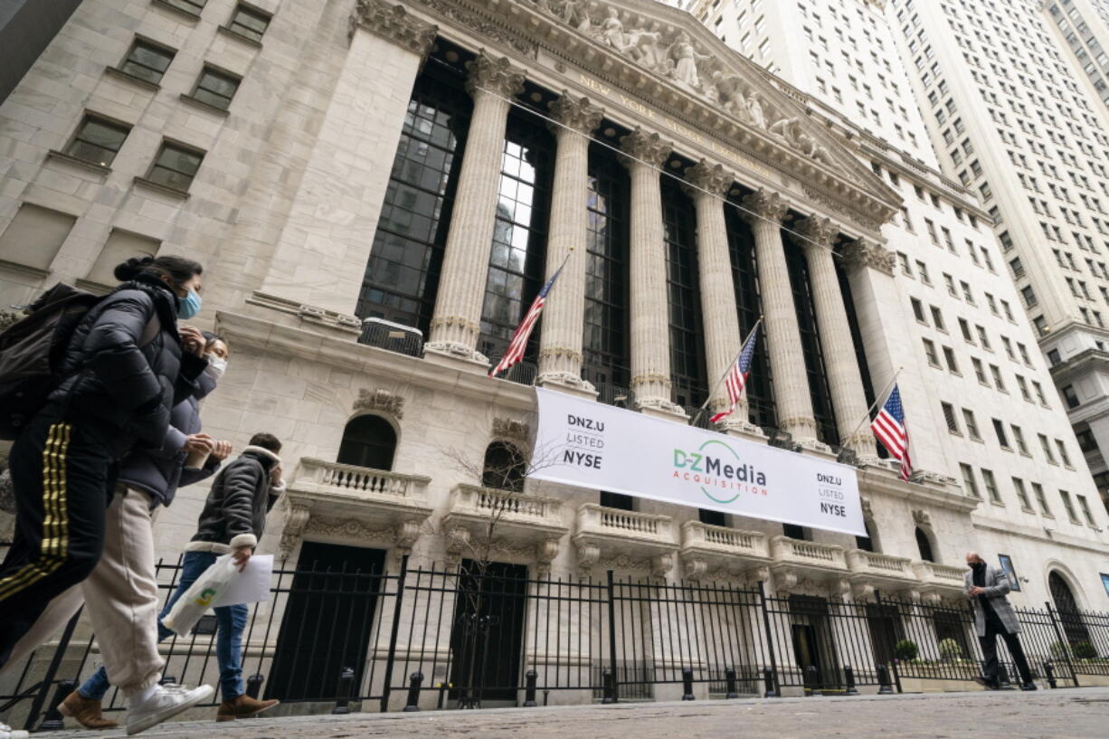 FILE - In this Jan. 27, 2021 file photo, pedestrians pass the New York Stock Exchange, in New York. Stocks were off to a mixed start on Wall Street Thursday, Sept. 16,  as gains for retailers are offset by drops in technology and materials companies.