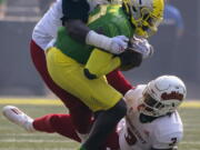 Oregon quarterback Anthony Brown (13) is wrapped up by Fresno State tackle Leonard Payne (55) and defensive end Aaron Mosby (3) during the first quarter of an NCAA college football game, Saturday, Sept. 4, 2021, in Eugene, Ore.