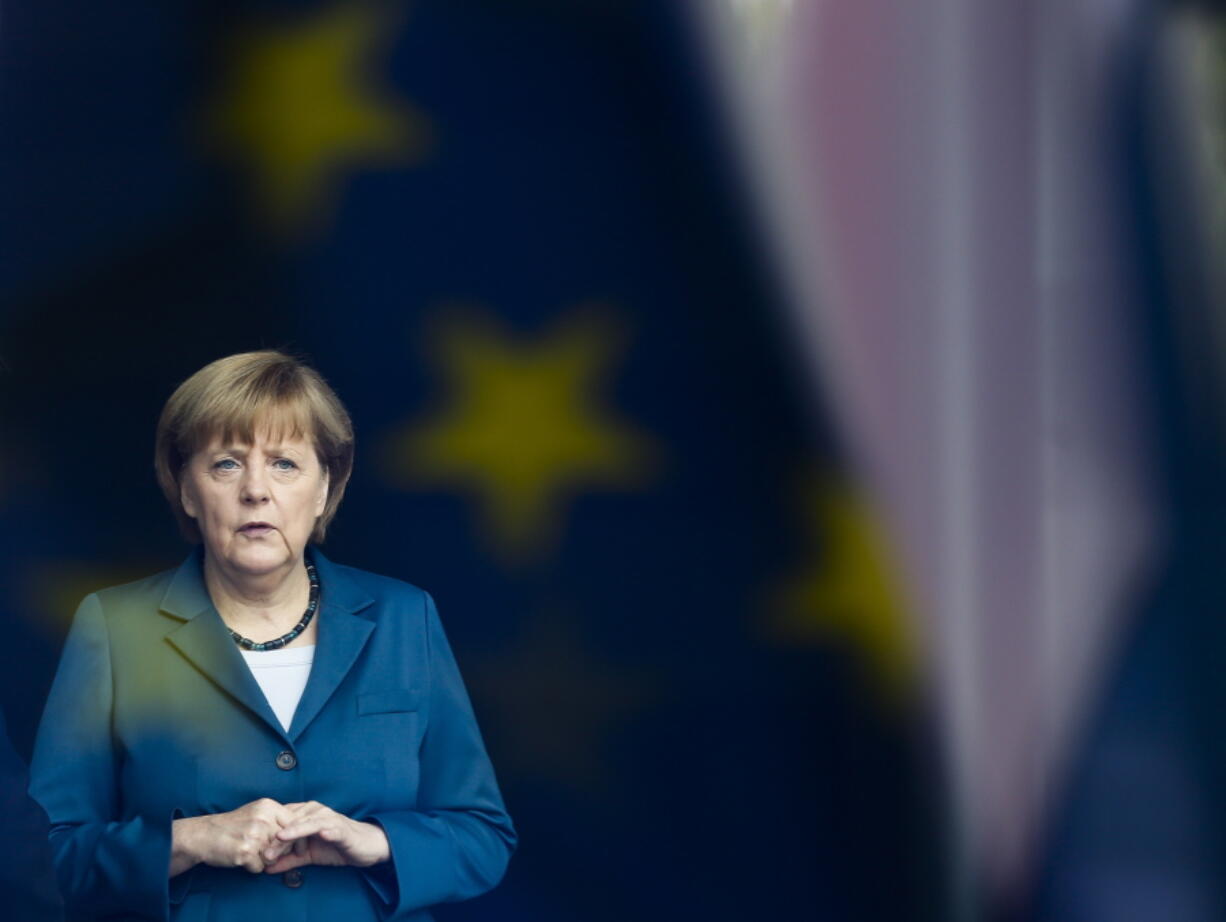 In this Monday, June 3, 2013 file photo, German Chancellor Angela Merkel stand behind a window with a reflection of the European flag as she waits for the arrival of King Willem-Alexander of the Netherlands at the chancellery in Berlin. Angela Merkel will leave office as one of modern Germany's longest-serving leaders and a global diplomatic heavyweight, with a legacy defined by her management of a succession of crises that shook a fragile Europe rather than any grand visions for her own country.