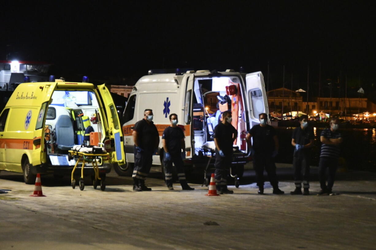 Paramedics wait next to ambulances at Pythagorio port, on the eastern Aegean island of Samos, Greece, late Monday, Sept. 13, 2021. Authorities in Greece Tuesday opened an investigation into the crash of a private plane from Israel that killed a prosecution witness in the corruption trial of former Israeli prime minister Benjamin Netanyahu. Haim Geron, a former senior official at Israel's ministry of communications, and his wife Esther were killed in the crash late Monday off the island of Samos.