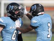 Hockinson’s Ty Litle gets a pat on the head from Kenyon Johnson after his second sack sealed the Hawks’ victory over Ridgefield on Saturday, March 13, 2021, at District Stadium in Battle Ground. Hockinson won 14-7 in the game between the 2A Greater St. Helens League’s top two teams.