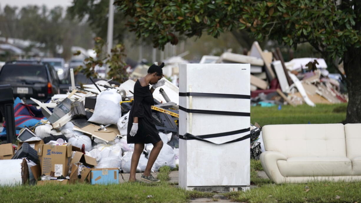 Lori Butler wipes her brow as she moves debris she is gutting from her home that was flooded, in the aftermath of Hurricane Ida in LaPlace, La., Tuesday, Sept. 7, 2021.