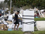 Lori Butler wipes her brow as she moves debris she is gutting from her home that was flooded, in the aftermath of Hurricane Ida in LaPlace, La., Tuesday, Sept. 7, 2021.