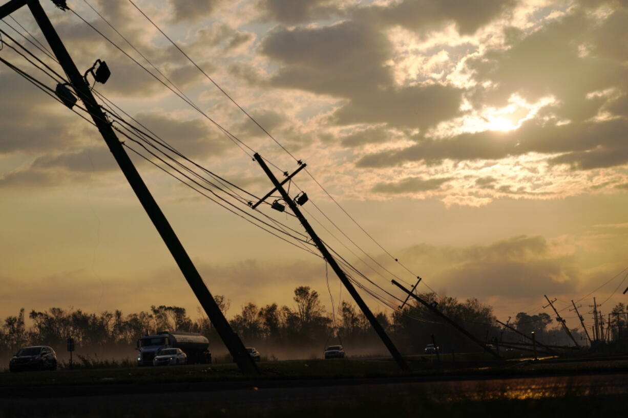 Downed power lines slump over a road in the aftermath of Hurricane Ida, Friday, Sept. 3, 2021, in Reserve, La. Power out, high voltage lines on the ground, maybe weeks until electricity is restored in some places -- it's a distressingly familiar situation for Entergy Corp., Louisiana's largest electrical utility.