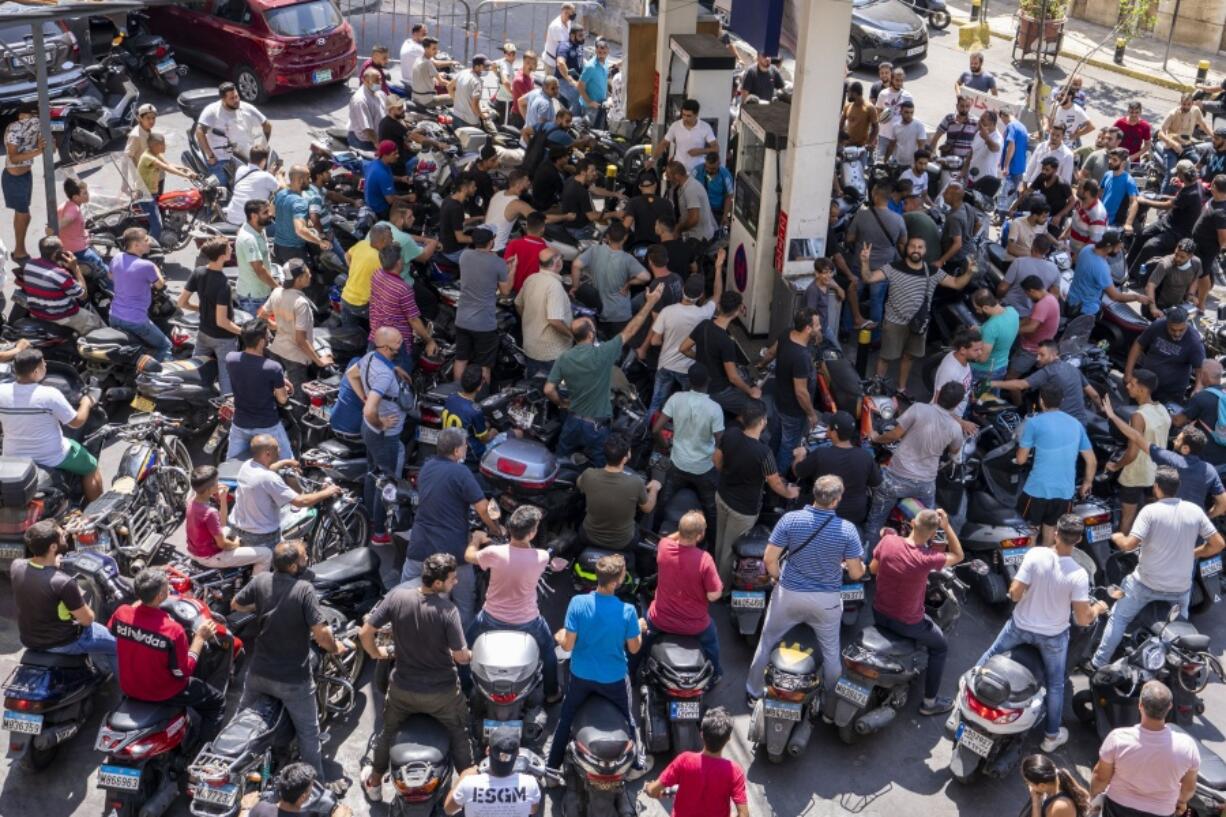 Motorcycle drivers wait to get fuel at a gas station in Beirut, Lebanon, Tuesday, Aug. 31, 2021. Lebanon is struggling amid a two-year economic and financial crisis that the World Bank has described as among the worst the world has witnessed since the mid-1850s. The crisis has left Lebanese suffering from severe shortages in fuel and basic goods like baby formula, medicine and spare parts.