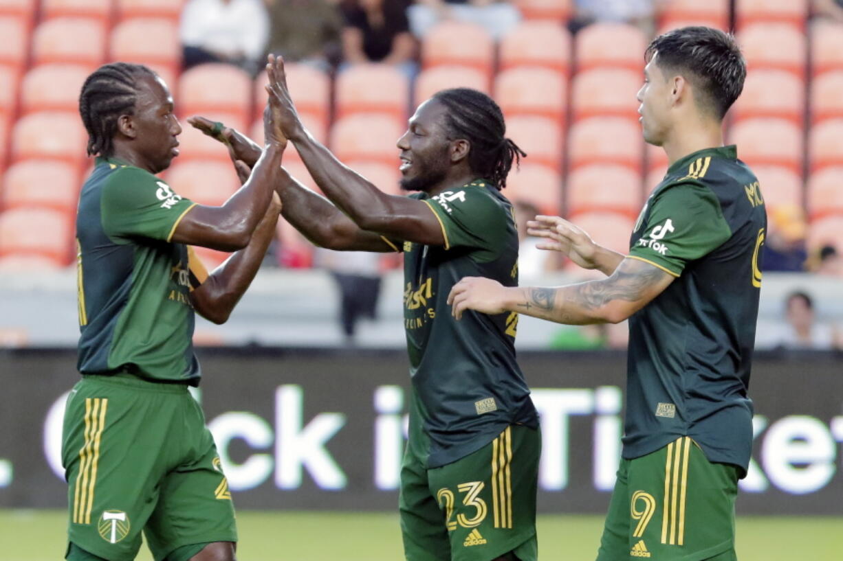 Portland Timbers' Diego Chara, left, Yimmi Chara, center, and Felipe Mora celebrate Yimmi Chara's goal.