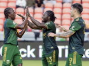 Portland Timbers' Diego Chara, left, Yimmi Chara, center, and Felipe Mora celebrate Yimmi Chara's goal.