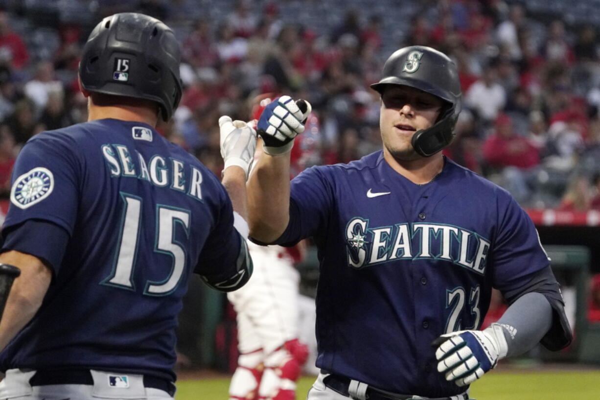 Seattle Mariners' Ty France is congratulated by Kyle Seager after hitting a solo home run during the first inning of a baseball game against the Los Angeles Angels Friday, Sept. 24, 2021, in Anaheim, Calif. (AP Photo/Mark J.