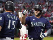 Seattle Mariners' Ty France is congratulated by Kyle Seager after hitting a solo home run during the first inning of a baseball game against the Los Angeles Angels Friday, Sept. 24, 2021, in Anaheim, Calif. (AP Photo/Mark J.