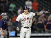 Houston Astros' Carlos Correa (1) celebrates after hitting a game-winning RBI ground-rule double against the Seattle Mariners during the 10th inning of a baseball game Tuesday, Sept. 7, 2021, in Houston. The Astros won 5-4 in 10 innings. (AP Photo/David J.