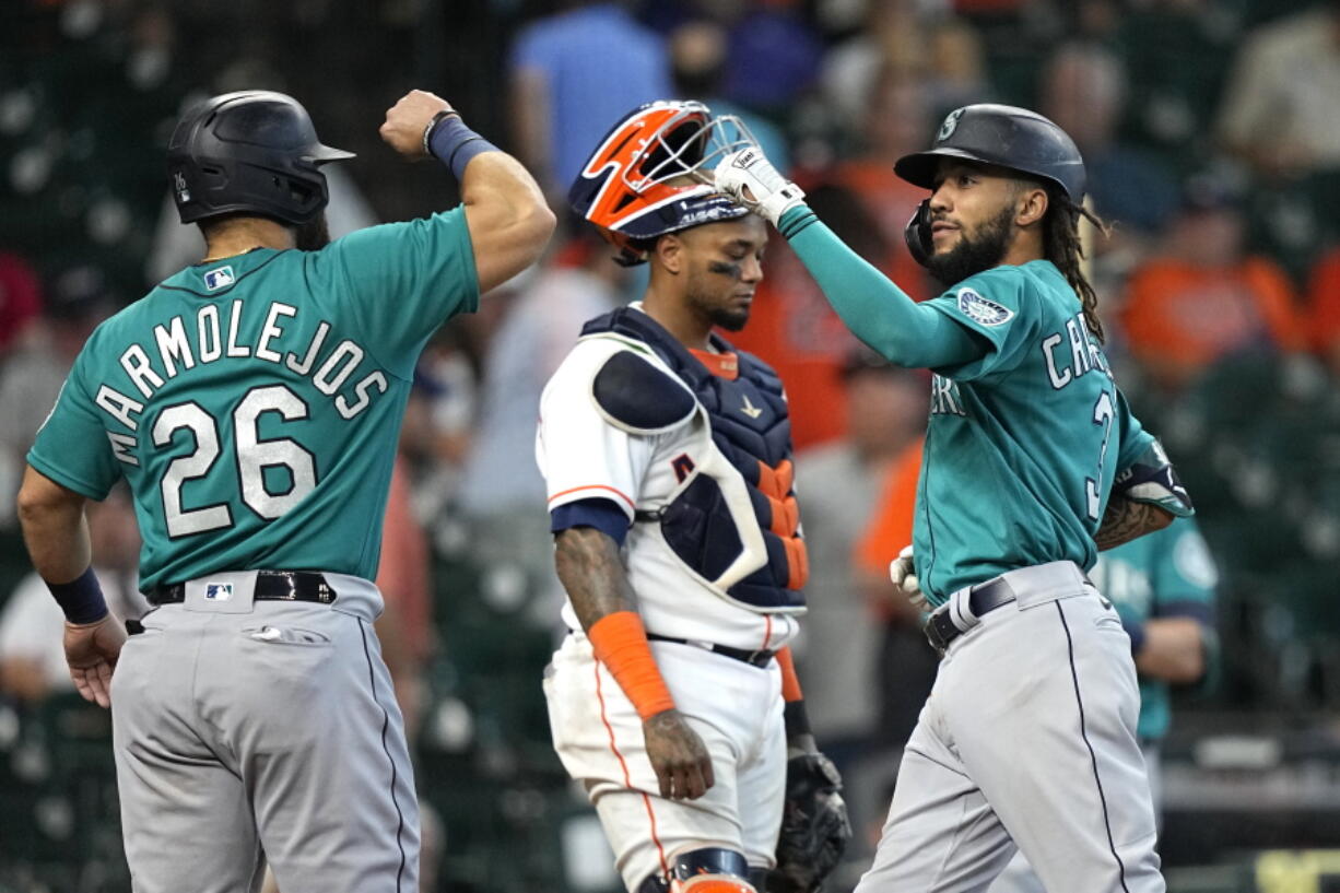 Seattle Mariners' J.P. Crawford (3) celebrates with Jose Marmolejos (26) after both scored on Crawford's two-run home run as Houston Astros catcher Martin Maldonado looks down during the ninth inning of a baseball game Wednesday, Sept. 8, 2021, in Houston. (AP Photo/David J.