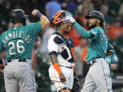 Seattle Mariners' J.P. Crawford (3) celebrates with Jose Marmolejos (26) after both scored on Crawford's two-run home run as Houston Astros catcher Martin Maldonado looks down during the ninth inning of a baseball game Wednesday, Sept. 8, 2021, in Houston. (AP Photo/David J.