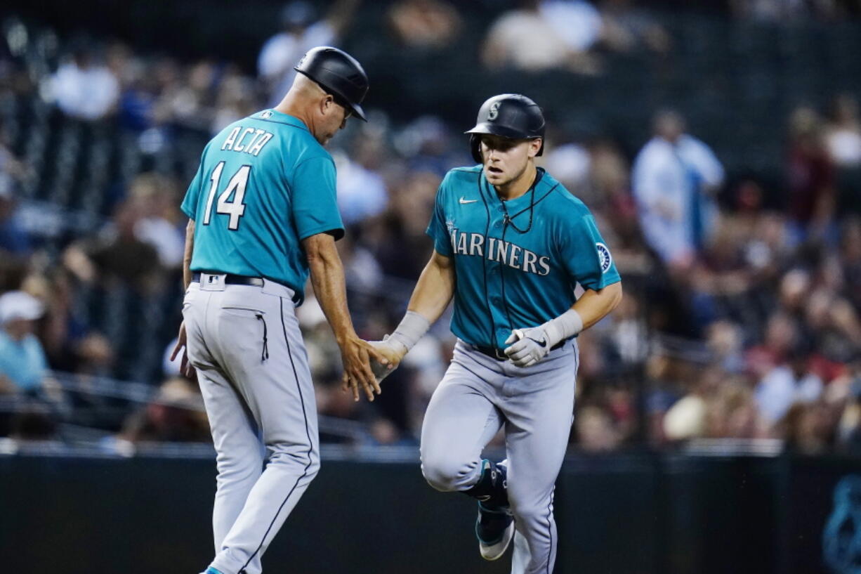 Seattle Mariners' Jarred Kelenic, right, celebrates his two-run home run against the Arizona Diamondbacks with Mariners third base coach Manny Acta (14) during the sixth inning of a baseball game Friday, Sept. 3, 2021, in Phoenix. (AP Photo/Ross D.