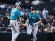 Seattle Mariners' Jarred Kelenic, right, celebrates his two-run home run against the Arizona Diamondbacks with Mariners third base coach Manny Acta (14) during the sixth inning of a baseball game Friday, Sept. 3, 2021, in Phoenix. (AP Photo/Ross D.