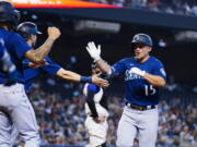 Seattle Mariners' Kyle Seager (15) celebrates his three-run home run against the Arizona Diamondbacks with Mariners' J.P. Crawford, left, and Mitch Haniger during the first inning of a baseball game Saturday, Sept. 4, 2021, in Phoenix. (AP Photo/Ross D.