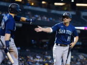 Seattle Mariners' Kyle Seager (15) celebrates his run scored against the Arizona Diamondbacks with teammate Jarred Kelenic (10) during the 11th inning of a baseball game Sunday, Sept. 5, 2021, in Phoenix. (AP Photo/Ross D.