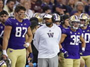 Washington head coach Jimmy Lake, center, stands on the sidelines late in the second half of Saturday's loss to 13-7 Montana in Seattle.