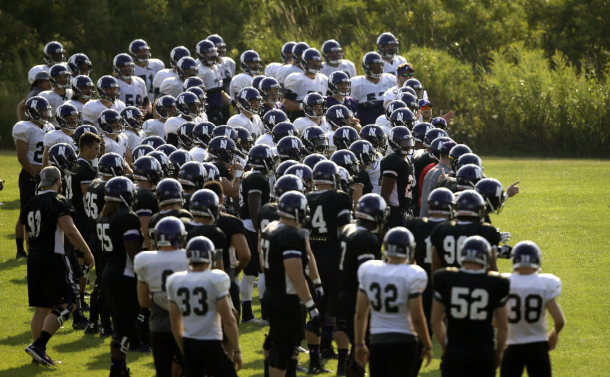 FILE - Northwestern football players gather during practice at the University of Wisconsin-Parkside campus in Kenosha, Wisc., in this Monday, Aug. 17, 2015, file photo. College football players and some other athletes in revenue-generating sports are employees of their schools, the National Labor Relations Board's top lawyer said in a memo Wednesday, Sept. 29, 2021, that would allow the players to unionize and otherwise negotiate over their working conditions.