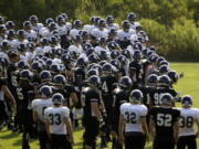 FILE - Northwestern football players gather during practice at the University of Wisconsin-Parkside campus in Kenosha, Wisc., in this Monday, Aug. 17, 2015, file photo. College football players and some other athletes in revenue-generating sports are employees of their schools, the National Labor Relations Board's top lawyer said in a memo Wednesday, Sept. 29, 2021, that would allow the players to unionize and otherwise negotiate over their working conditions.