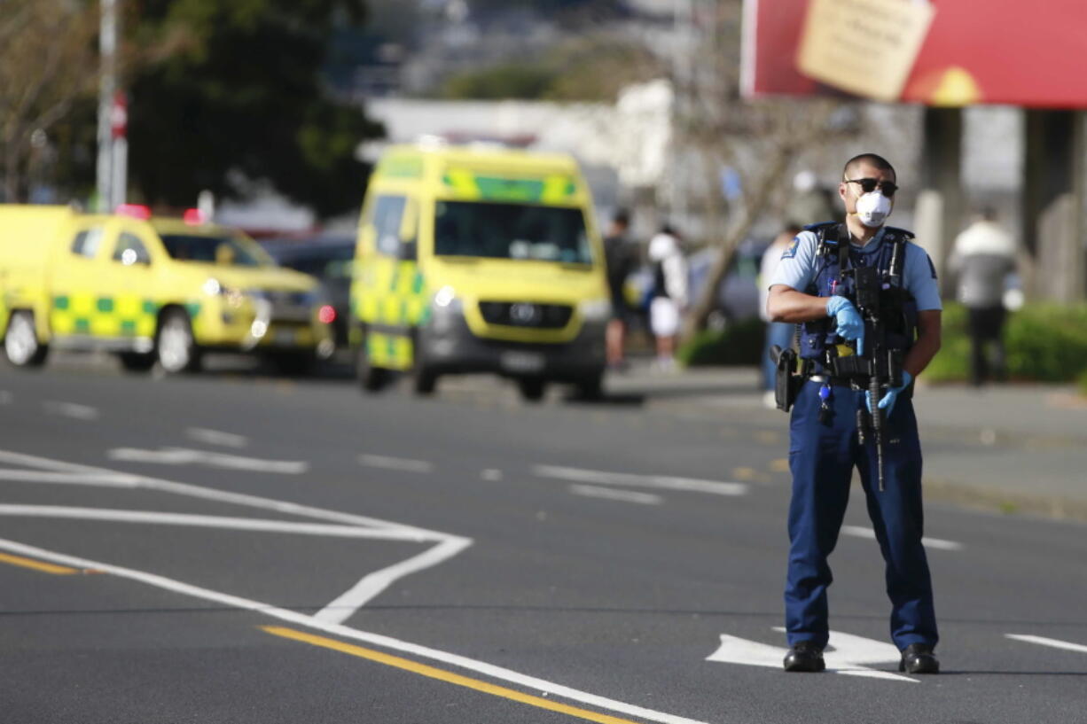 A police officer stands outside an Auckland supermarket, Friday, Sept. 3, 2021. New Zealand authorities said Friday they shot and killed a violent extremist after he entered a supermarket and stabbed and injured several shoppers. Prime Minister Jacinda Ardern described the incident as a terror attack.